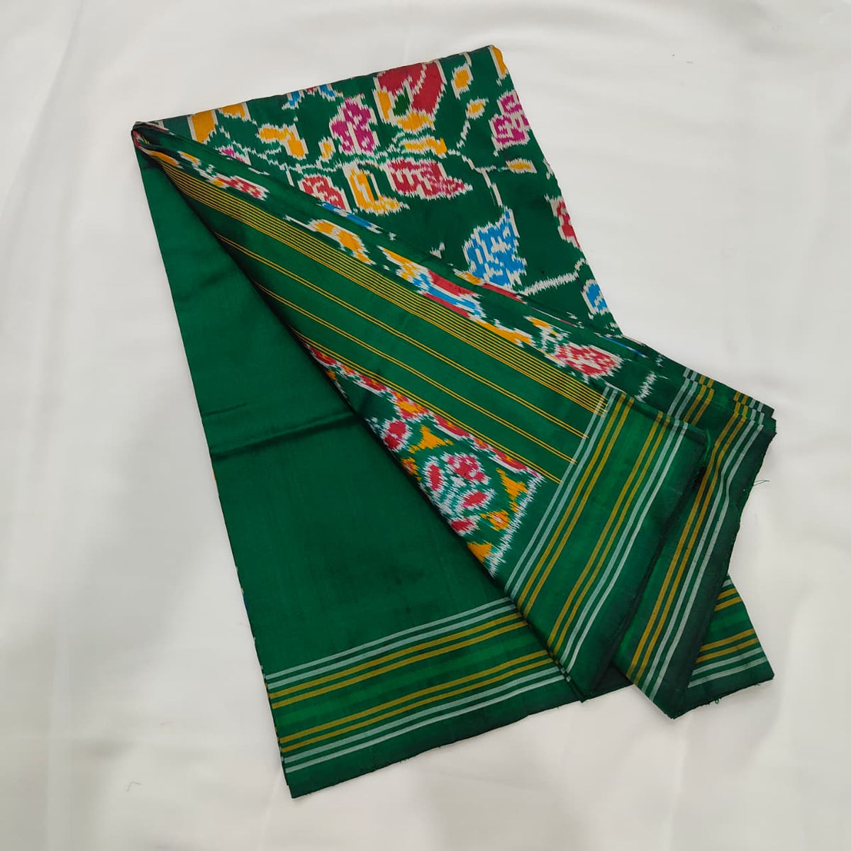 Emerald green ikat silk saree, floral motif and striped border detail
