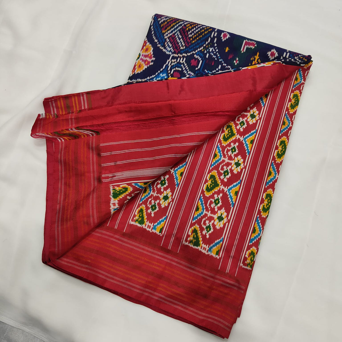 Navy blue ikat silk saree, pallu and pink-red contrast border detail
