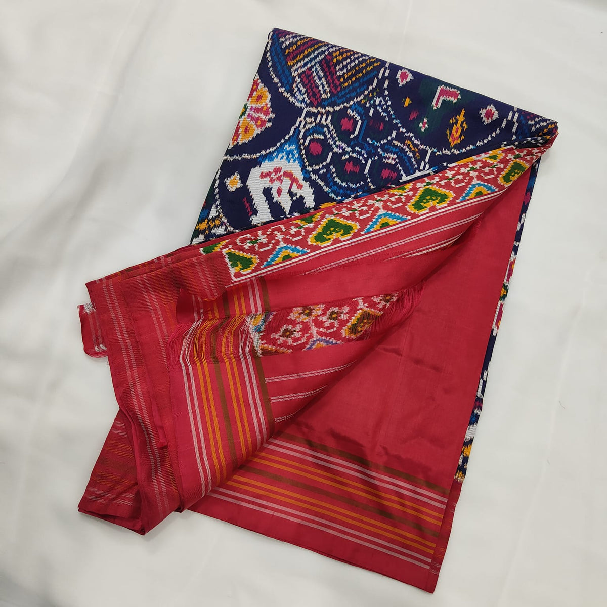 Navy blue ikat silk saree draped to show the body and border together