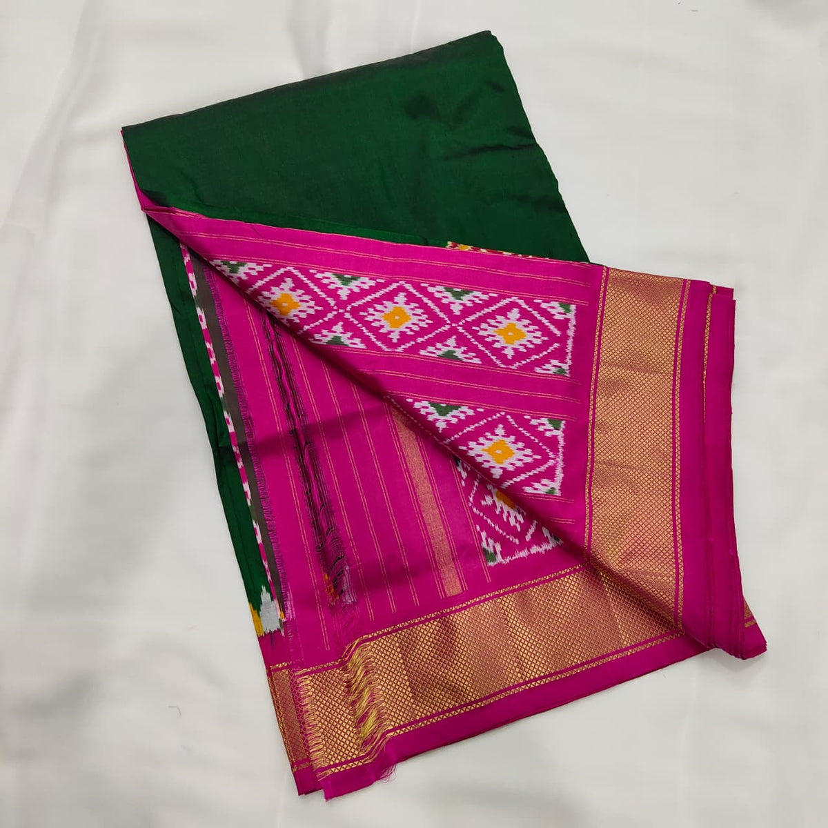 Bottle green ikat silk saree draped to show the body and pallu