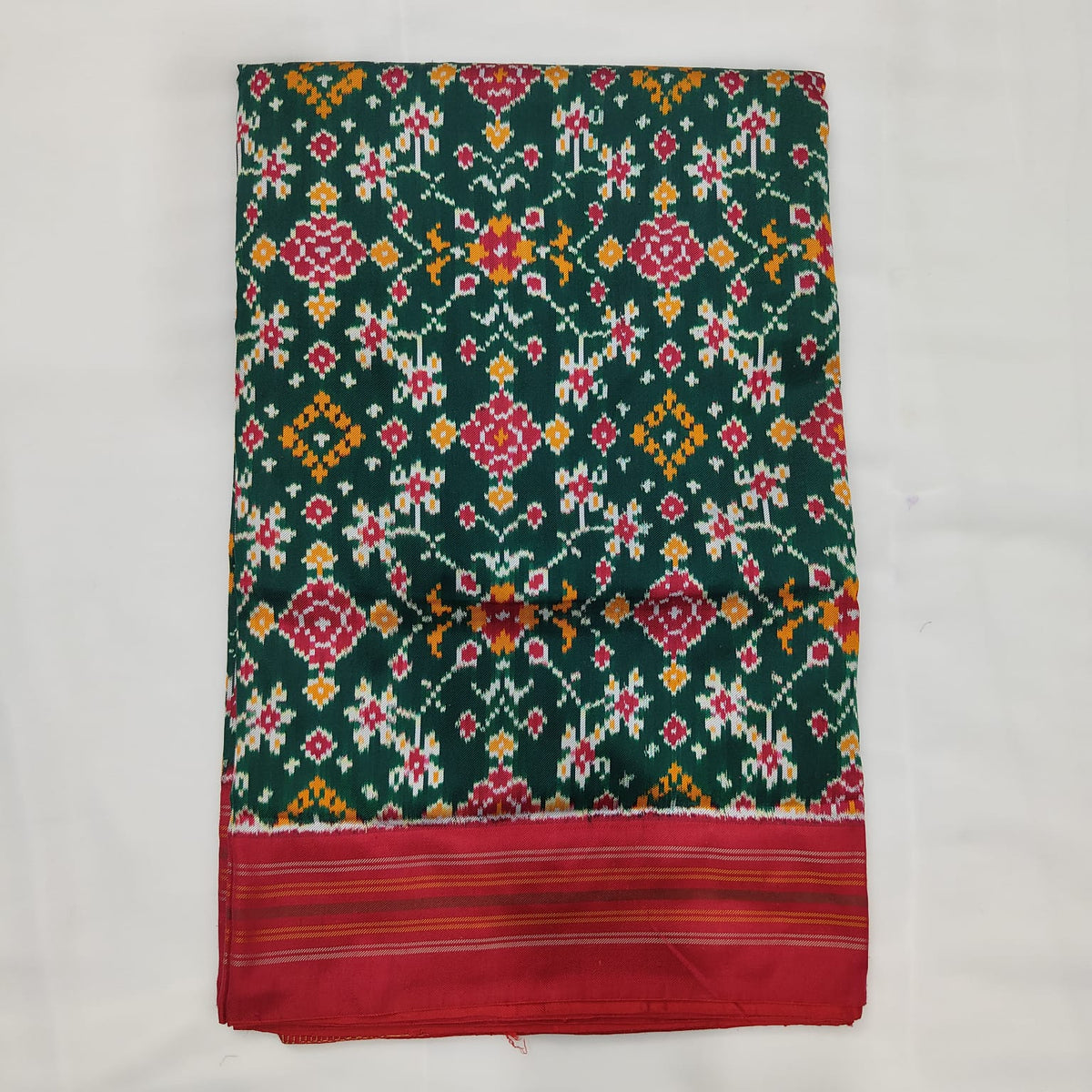 Deep green ikat silk saree, floral motif and red border detail