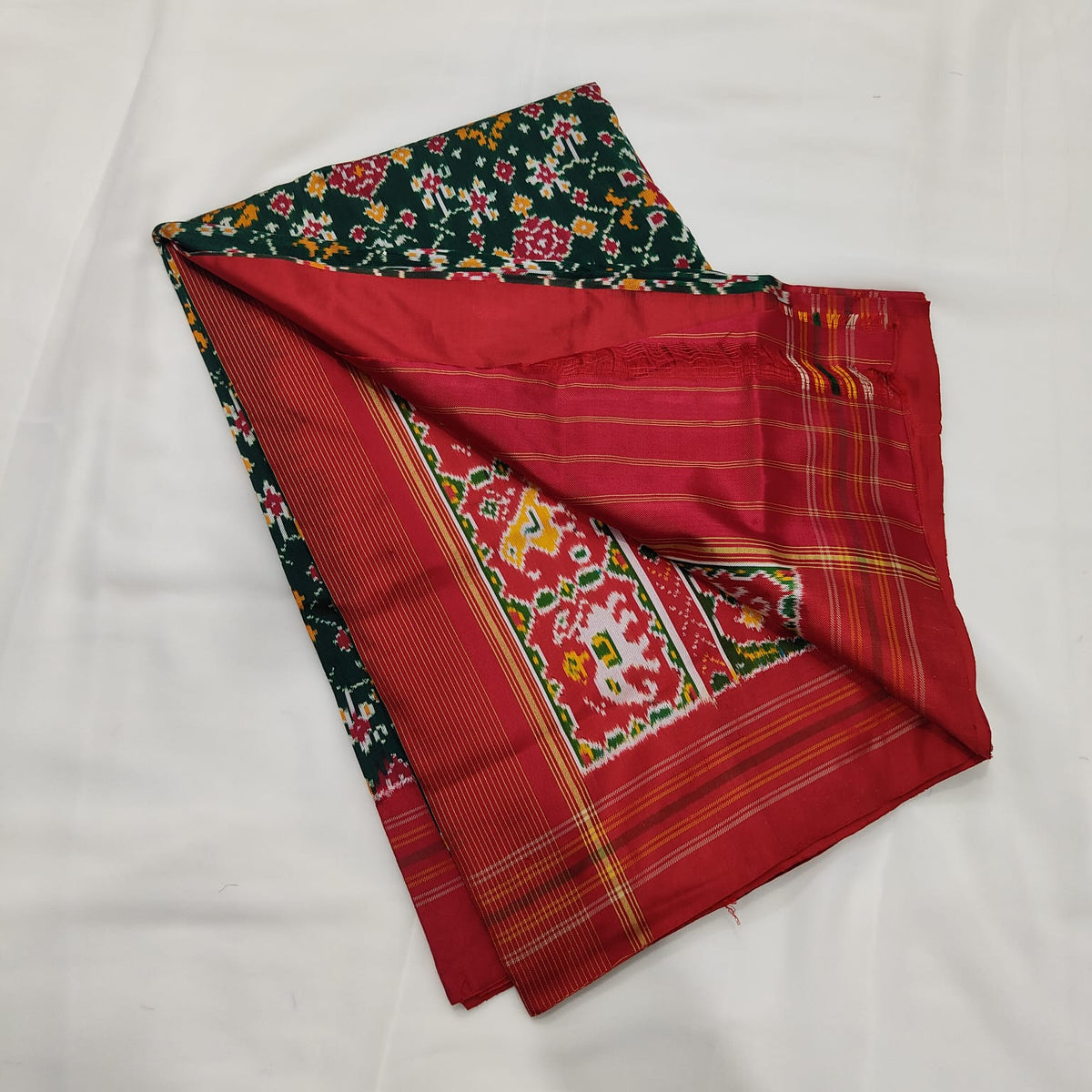 Deep green ikat silk saree draped to show the body and pallu