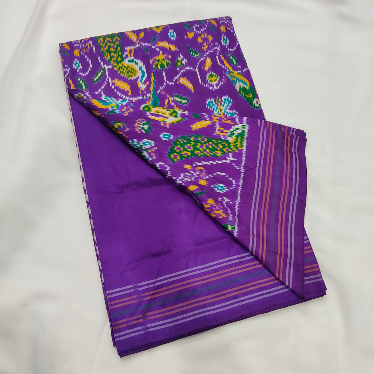 Purple ikat silk saree draped to show the body and pallu