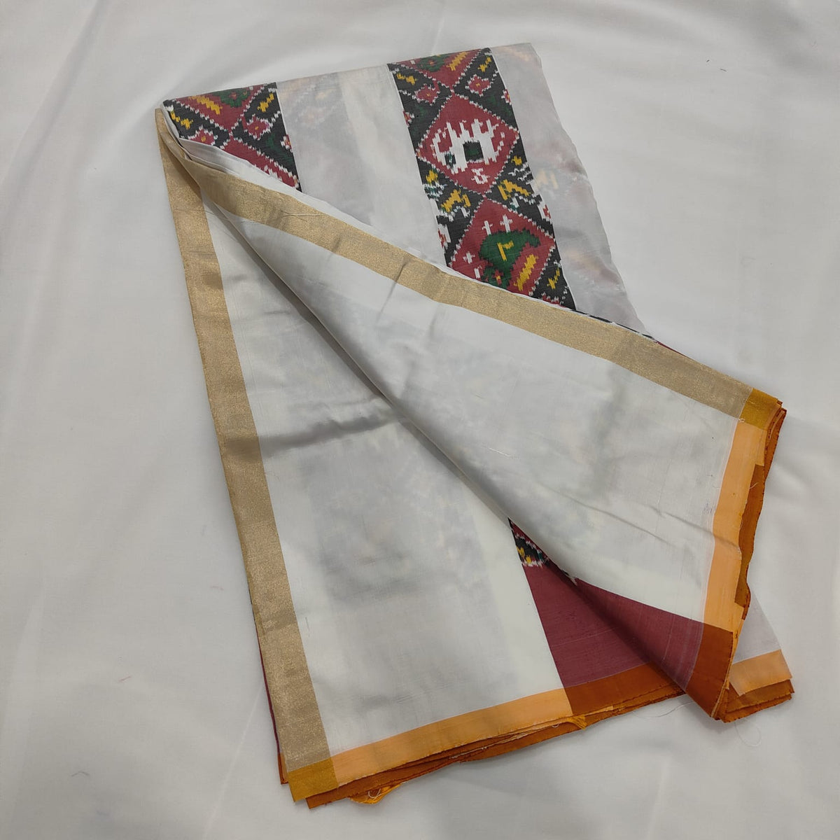 Ivory ikat silk saree draped to show the body and pallu
