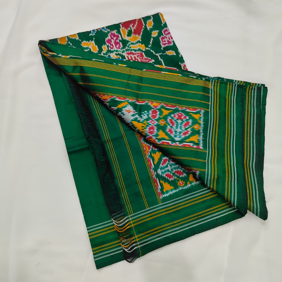 Emerald green ikat silk saree draped to show the body and pallu
