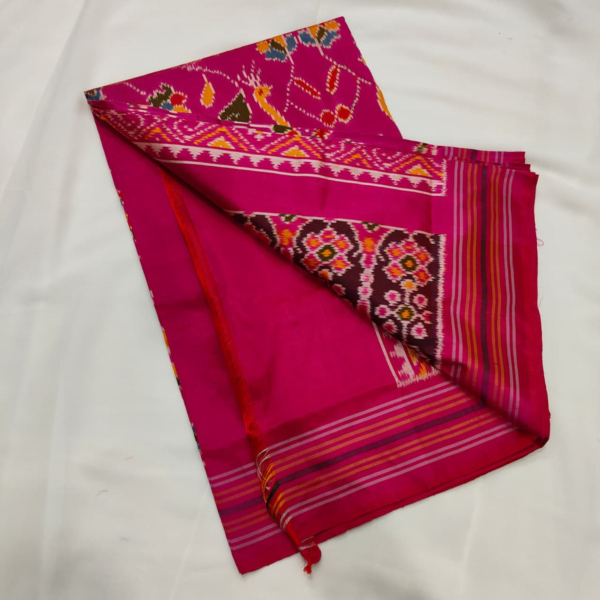 Magenta pink ikat silk saree draped to show the body and pallu