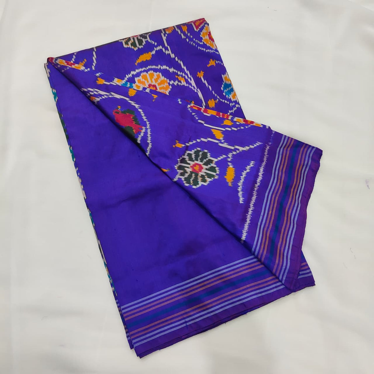 Violet blue ikat silk saree, rosette motif and striped border detail