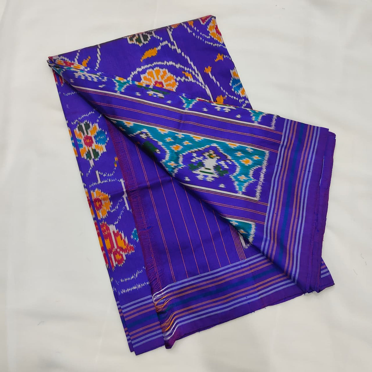 Violet blue ikat silk saree draped to show the body and pallu